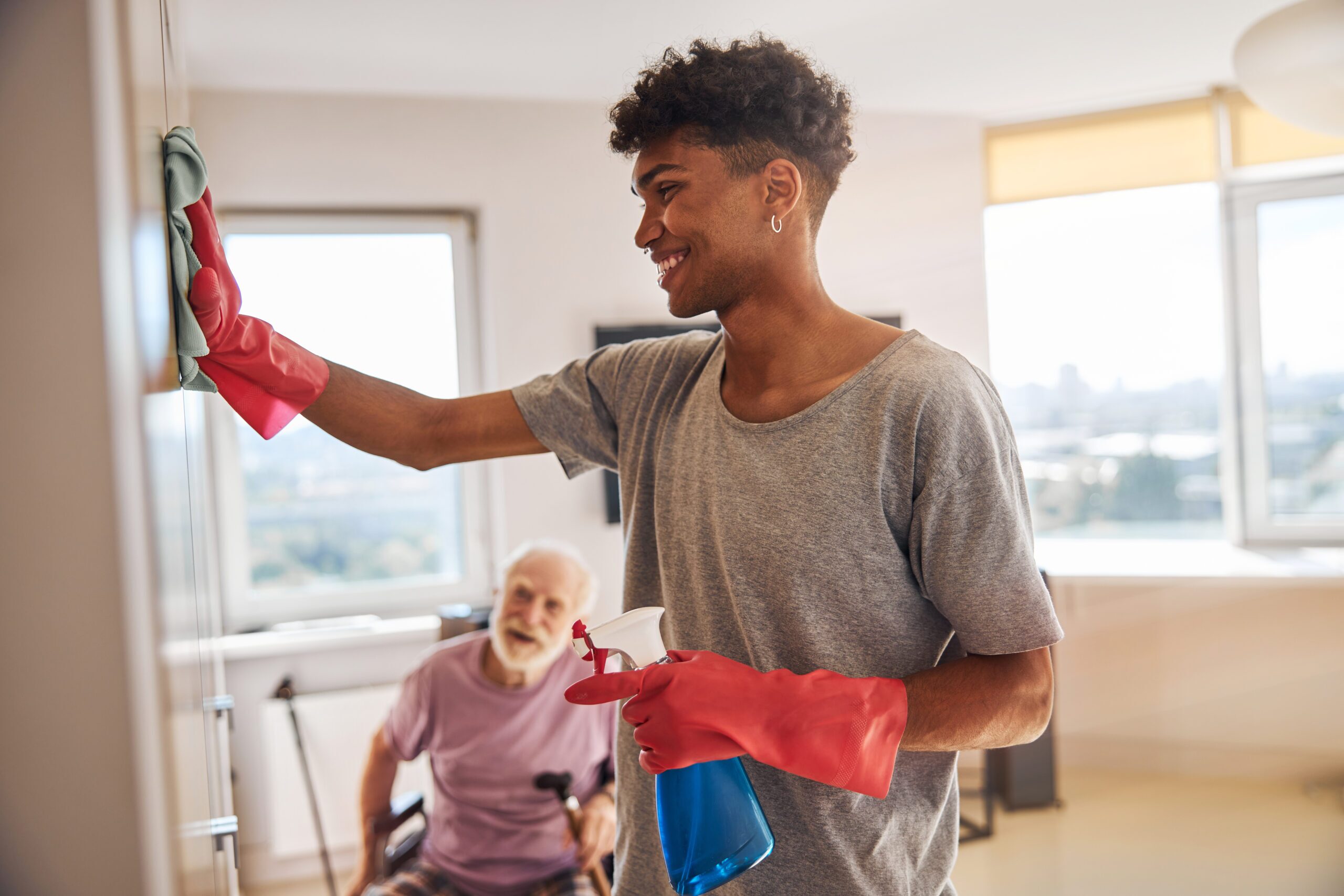 Caregiver helping a senior man tidy his room